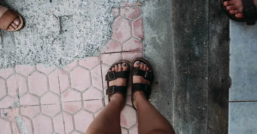 A close-up shot of perfectly manicured feet, with glossy black nail polish adorning the toes. The dark hue contrasts beautifully against the skin, exuding an edgy and sophisticated vibe.