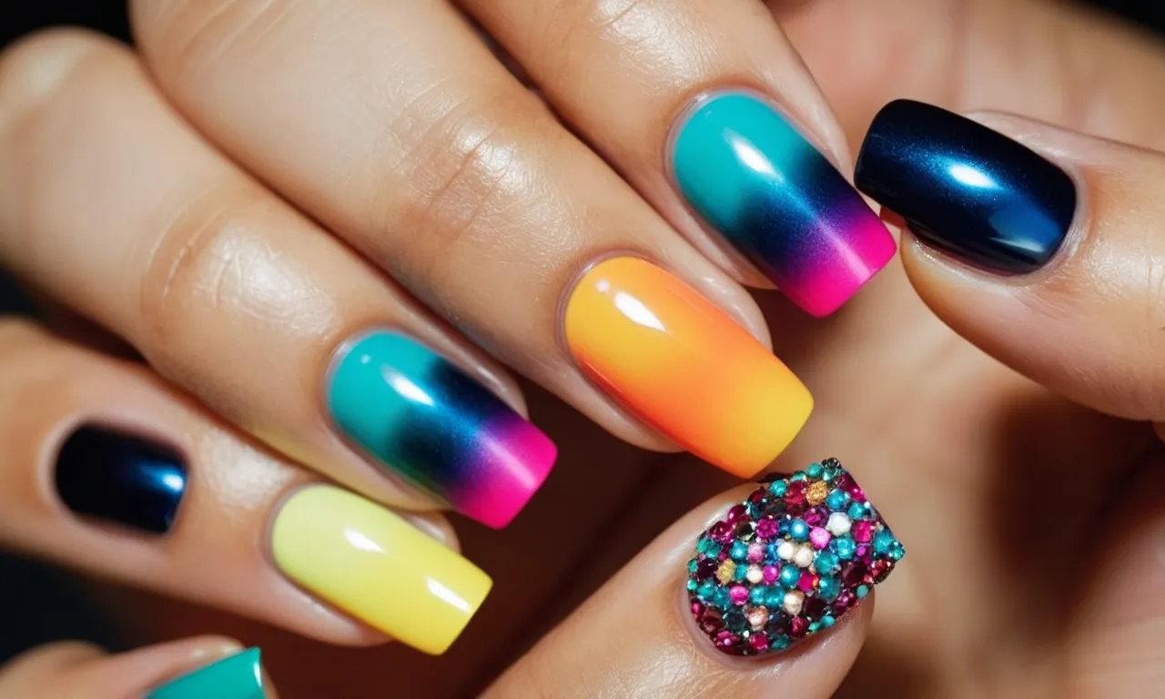A close-up shot of a hand adorned with vibrant and intricately designed press-on nails, featuring a variety of vivid colors and a chic French tip finish.